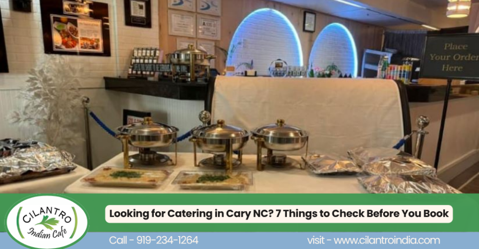Catering setup at Cilantro Indian Cafe in Cary, NC, featuring covered stainless-steel serving dishes and prepared food trays, with a promotional banner reading Looking for Catering in Cary NC? 7 Things to Check Before You Book.
